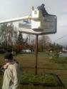 Bro. Sweet and Bro. Moore work to get the sign on the pole.